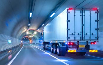 Ein LKW auf einer Autobahn, beladen mit Kisten und Paketen, symbolisiert den zuverlässigen Service von Eiltransporten, die Lieferungen schnell und effizient ans Ziel bringen.